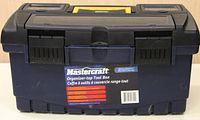 Closed front view of the black and yellow Mastercraft toolbox with label