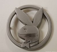 Front view of the Playboy Bunny belt buckle showing the silver-tone metal and rhinestone eye detail.