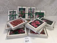 Multiple sets of floral notecards stacked and tied with green ribbons, showing various flower images on the front of the cards.