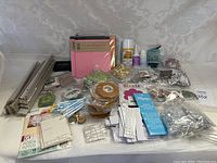 Wide view of all crafting supplies including albums, ribbons, adhesives, and embellishments arranged on a surface.