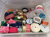 Photo showing assorted ribbons in two plastic bins, including various colors and patterns.