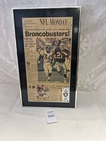 Front view of framed NFL Monday newspaper clipping titled 'Broncobusters!' featuring action photo of Raiders and Broncos players and text about Kaufman's 227 yards.