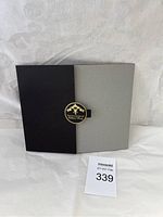 Closed black and gray folio with Thomas Kinkade Collectors Society logo clasp.