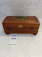 Front view of the rectangular carved cedar box with brass latch and decoupage lid showing lake scene