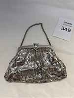 Front view of the Whiting Davis small silver toned evening bag showing the metal mesh, chain strap and rhinestone snap clasp.