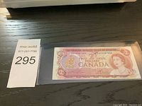 Image of front side of Canadian two dollar bank note, showing Queen Elizabeth II portrait and serial number AGE0387050.
