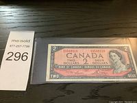 Front side of the 1954 Canadian two dollar note showing Queen Elizabeth II portrait, serial number, and denominations in English and French.