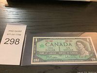 Front of the Canadian Centennial one dollar note showing Queen Elizabeth II and commemorative text.