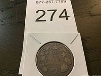 Photo of 1875 Canadian half dollar coin in protective holder showing front with crown, maple leaves, and date.