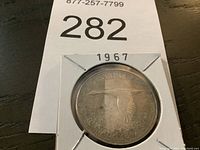 Front side view of the 1967 Canadian dollar coin showing the flying goose design and partial inscriptions.