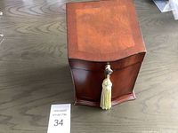 Closed wooden jewellery box with key and tassel