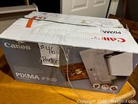 Box of Canon PIXMA iP1600 printer with shipping labels and some wear.