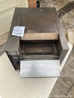 Front top view of the APW Wyott 606 rolling toaster showing the conveyor rack and crumb tray.