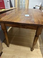 View of the hardwood table's turned wooden leg and groove details.