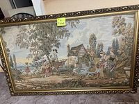 Frontal photo of large framed farm scene picture showing details of figures, animals, watermill, and ornate gold frame.