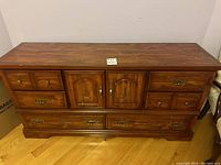 Front view showing top surface, drawers, cabinet doors, and brass hardware