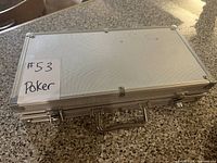 Silver aluminum poker chip carrying case with latch and handle, closed.