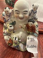 Photo showing the porcelain Buddha statue with five children surrounding it, detailed colorful painting, and smooth finish.