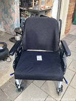 Front view of black wheelchair seat and armrests labeled 'USD Wheel Chair'