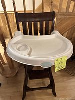 Wooden Carter's high chair with attached white plastic tray, showing front view including cup holder