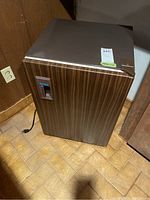 Front and top view of Danby bar fridge showing wood grain finish and power cord.