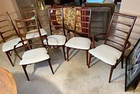 Six ladder-back chairs grouped in a row, showing overall design and upholstery