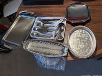 Overview of four metal trays varying in shape and size plus boxed Muller cutlery set