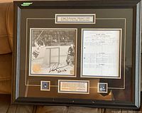 Full view of framed display showing print, score sheet, pins and plaque