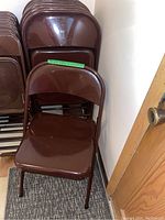 Front view of a brown metal folding chair showing overall condition and color