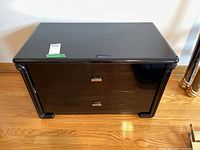 Front view of black lacquer two-drawer nightstand
