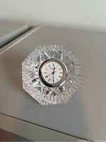 Front view of the Waterford crystal clock showing the clock face with Roman numerals within the intricately cut crystal body.