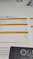 GRA Moissanite grading report showing 1 carat weight, VVS1 clarity, D color, excellent cut, polish, and symmetry.
