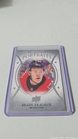 Brady Tkachuk rookie hockey card in protective sleeve showing front with portrait image and text.