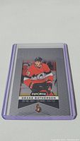 Front face of Drake Batherson rookie card in protective sleeve showing player in red Ottawa Senators jersey, card text and design