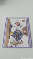 Front view of Elias Pettersson rookie hockey card in protective purple case on plain white background