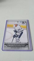 Front of Matthew Knies rookie hockey card in protective sleeve showing player in Maple Leafs uniform, labeled Debut Dates, dated April 10, 2023.