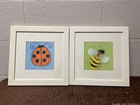 Two framed insect paintings by Anthony Morrow side by side on a brown cloth backdrop, showing the ladybug and bumblebee images.
