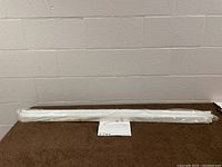 Full view of the Green Watt LED strip light in original plastic wrapping, lying on a table with a white wall background