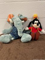 Both vintage plush toys, Ganz Wrinkles elephant puppet and Disney Goofy plush.