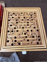 Wooden labyrinth maze game board with holes and maze track