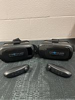 Both VR headsets placed side by side with their respective controllers in front, showing full items included in the lot.