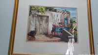 Full view of the original watercolor painting showing a southwestern adobe house entrance with detailed door, window, pottery and cart wheel.