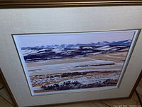 Full view of the framed acrylic painting depicting snow-covered fields and mountains under warm light