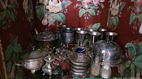 Overview of lot items including silver plated tea pot, goblets, coasters, salt and pepper shakers and covered dish.