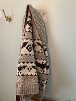 Side and front views of knitted sweater highlighting the pattern and knit texture.