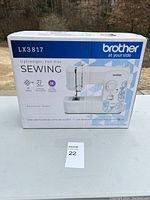 Front view of boxed Brother LX3817 sewing machine showing model and features.