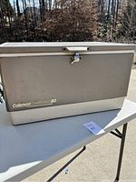 Front view of the vintage Coleman Steel Belted 80 cooler showing the latch, logo and overall condition.