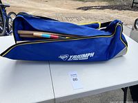 Full view of the zipped blue canvas carrying bag with Triumph All Pro Series branding, carrying croquet set items.