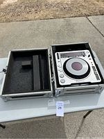 Pioneer CDJ-800MK2 DJ compact disc player inside black foam-lined protective case shown open on table.