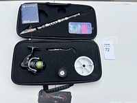 Overall set displayed in foam case showing rod, reel, spool, hook, tackle box, additional reel part, and manual.